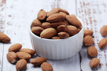 A small bowl with almond at white background	