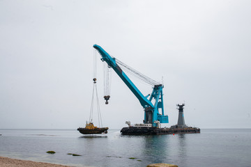 Fototapeta premium a large floating crane saves a barge aground in Odessa