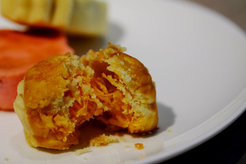 Chinese pastry with golden yolk thread inside on white plate, special recipe sweet, high sugar level that affect illness such as diabetes, served with sugar or tea, sold in market and restaurant