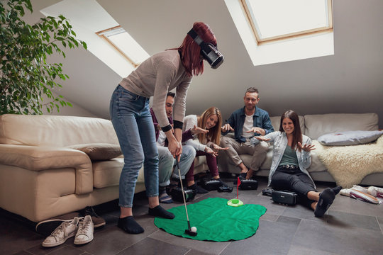 Group Of Young Adults Have Fun Playing Golf With Virtual Reality Glasses