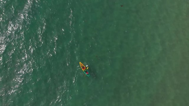 Aerial Top View of a Sandy Beach With Turquoise Water and visitor in kayaking around beach at Labuan, Malaysia