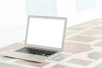 Fototapeta premium Outdoor remote working by light gray color laptop computer with white screen on granite texture desk and right side copy space
