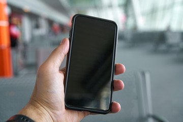 Smartfon trzymany przez męską dłoń - obrazy, fototapety, plakaty