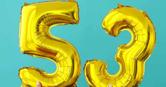 Gold foil number 53 celebration balloon on a blue background