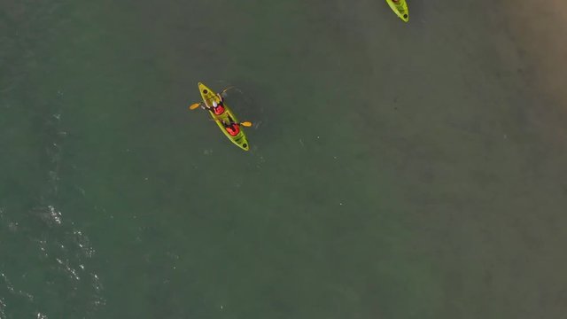 Aerial Top View of a Sandy Beach With Turquoise Water and visitor in kayaking around beach at Labuan, Malaysia