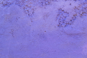 The texture of the concrete wall is purple. A raw plaster wall background