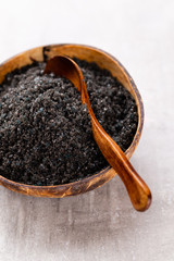 Sea salt in bowl, aroma oil in bottles, Wellness and flowers on grey textured background and...