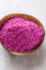 Sea salt in bowl, aroma oil in bottles, Wellness and flowers on grey textured background and flowers on vintage wooden background. Selective focus.