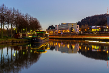 Germany, Traffic and street lights reflecting in silent water of saarbrucken in magic hour