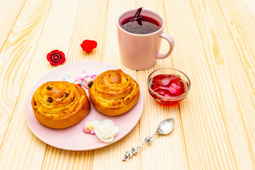 Karkade tea from hibiscus petals (Sudanese rose). Gentle romantic breakfast concept. Buns, meringues, strawberry jelly. On a wooden background.