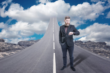 Obraz premium Businessman standing on road that goes up to the sky
