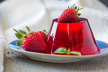 Photo of fruit jelly with fresh strawberry. Healthy food. Strawberry jelly on white plate. Summer dessert with fruit jelly and fresh strawberry. - 265446412
