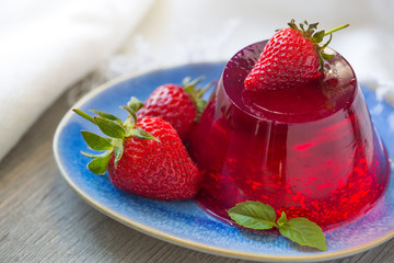 Photo of fruit jelly with fresh strawberry. Healthy food. Strawberry jelly on white plate. Summer dessert with fruit jelly and fresh strawberry. - 265446820