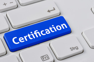 A keyboard with a blue button - Certification