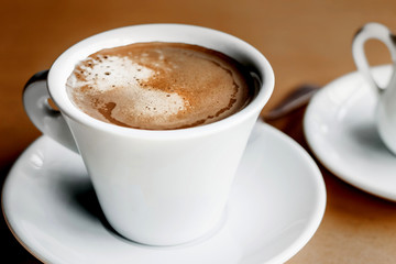 Morning coffee closeup on a wooden table background in a cafe, vintage color tone