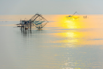 Fototapeta na wymiar Tourists on the long tail boat at sunrise, net fishing of fishermen, Pakpra, Phatthalung, Thailand.