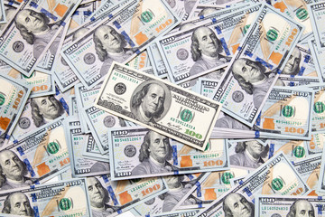 One hundred dollar bills on the table as background