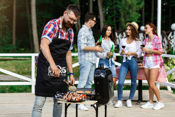 Obraz premium Small group of friends drink alcohol and having a meal at barbecue party. Diverse People Friends Hanging Out Drinking Concept