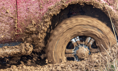 Fototapeta na wymiar Car wheel slips in the dirt in nature