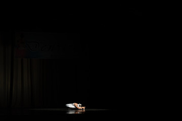 balerina lying down in darkness,  with space for text