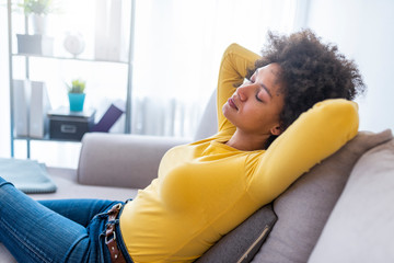 Portrait of a girl relaxing on a sofa after work at home sitting on a sofa in the living room at...