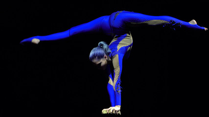 Flexible beautiful slim gymnast artist performing on the stage.
