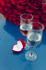 engagement ring placed on the wing of a plane with a bouquet of flowers, red roses