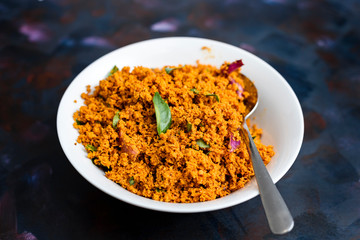 Coconut sambal, a Srilankan/ Indian spicy dish, in a bowl on a textured background.