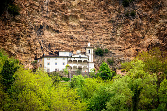 View of the beautiful Hermitage of Calomini (Eremo di Calomini), placed in a spectacular position, at the base of a sheer limestone wall. Vergemoli, Lucca, Garfagnana, Tuscany, Italy