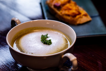 close up of mushroom soup in white ceramic cup on table