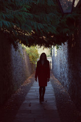 Silhouette of a woman in a narrow lane