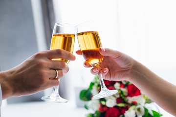 Newlyweds hold wineglasses of champagne. wedding bouquet on the
