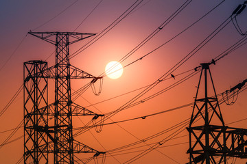 high voltage steel transmission tower during sunset