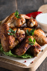 Close-up photo of bbq chicken wings with fries and beer. Barbeques meat with sauces, ketchup, mayonnaise. Fast and junk food concept. 