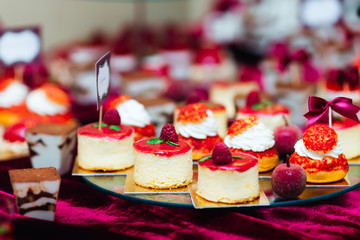 candy bar at the wedding. sweet cupcakes decorated with raspberr