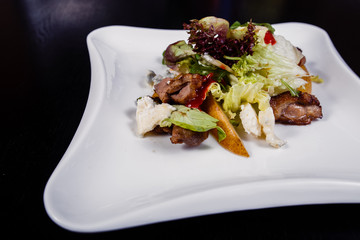 Appetizing salad sliced with pear slices of prosciutto pear arugula and parmesan