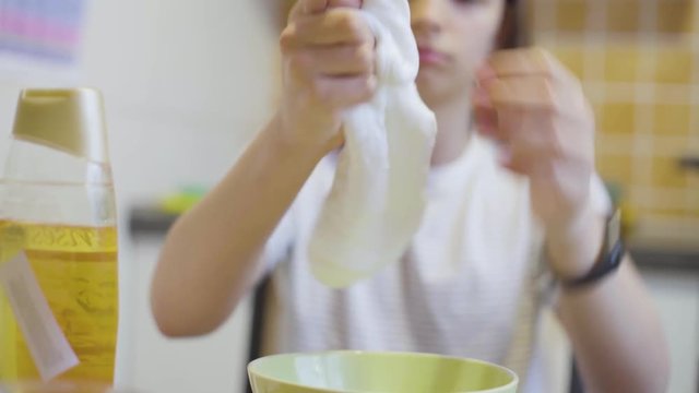 closeup of school girl hands playing with homemade white slime