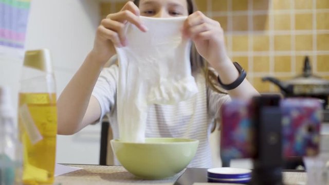 teen girl squeezing and playing with homemade white slime