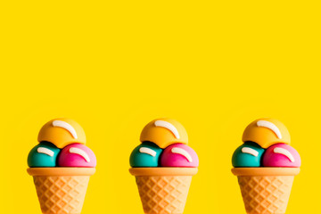 Ice cream cone plastic toy assorted flavors on a yellow background