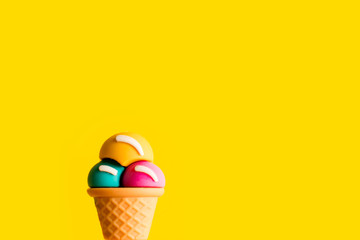 Ice cream cone different flavors on a yellow background. plastic toy macro