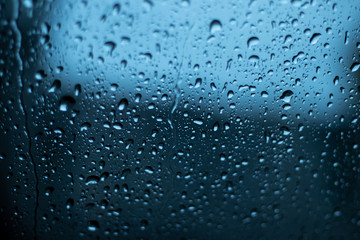 Fototapeta na wymiar Glass in drops of water on a blue background