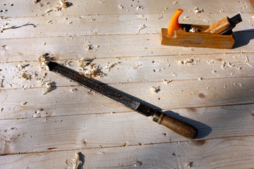 restoration of an old wooden table from pine planks in the workshop, carpentry tools, chisel.
