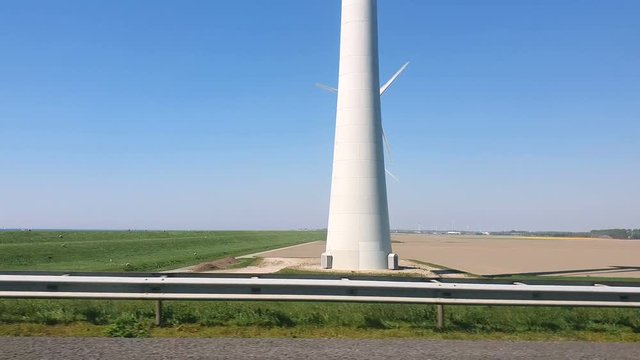 Windmill park in the lake IJsselmeer in Flevoland Netherlands. View from the car window at speed.