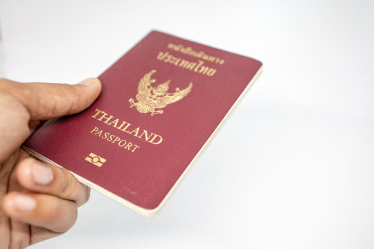 Hand on Thai Passports for people of Thailand with Thai language mean to Thailand Country. Design on Crimson colur