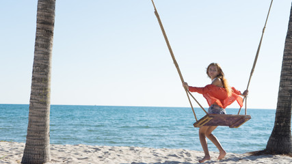 Vacation concept. Young woman swing on a beach swing. Happy traveller women on the Phu Quoc beach