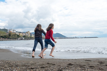 Mädchen spielen am Strand von Salerno Italien