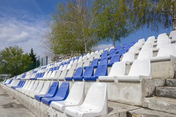 White and blue plastic empty stadium seats in arena.