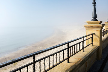 fog on the beach in spring day with metal border on embankment in Odessa