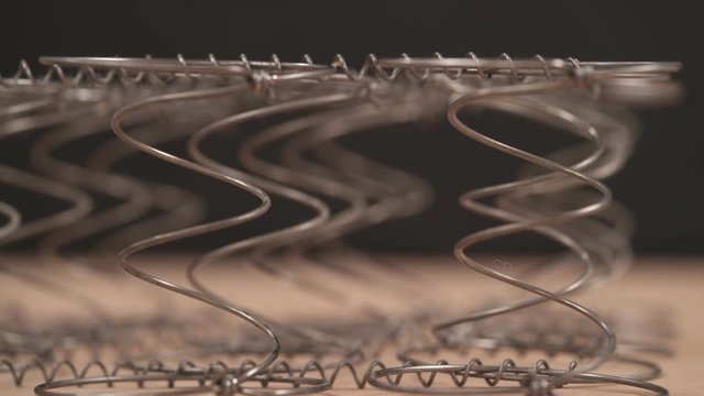 A demonstration video of an expert worker checking mattress coils flexibility. Furniture making concept