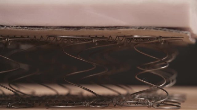A close-up of an expert worker checking offset coils flexibility. Furniture manufacture concept